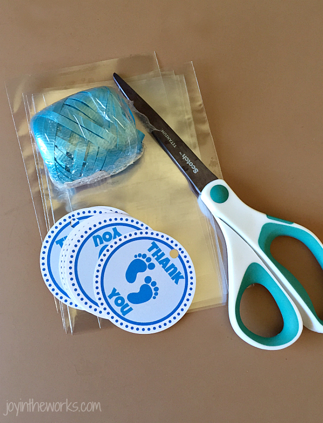 To wrap your marshmallow pops, you need cellophane bags, scissors, ribbon and gift tags.