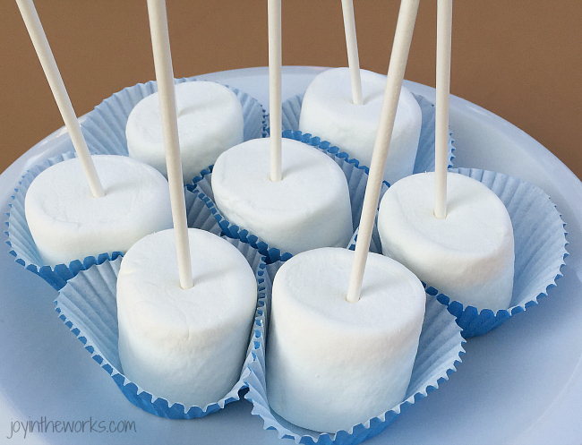 To make marshmallow pops, start by Inserting a lollipop stick into each marshmallow.
