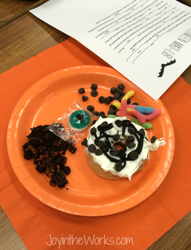 Decorated donut on a plate with candy and sweet toppings