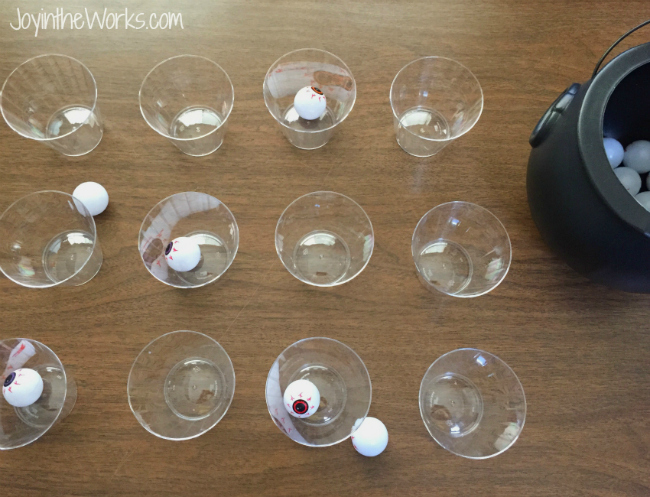 Play eyeball pong with plastic eyeballs, cups and a cauldron for a Halloween party game at your Halloween class party. Simple and fun!