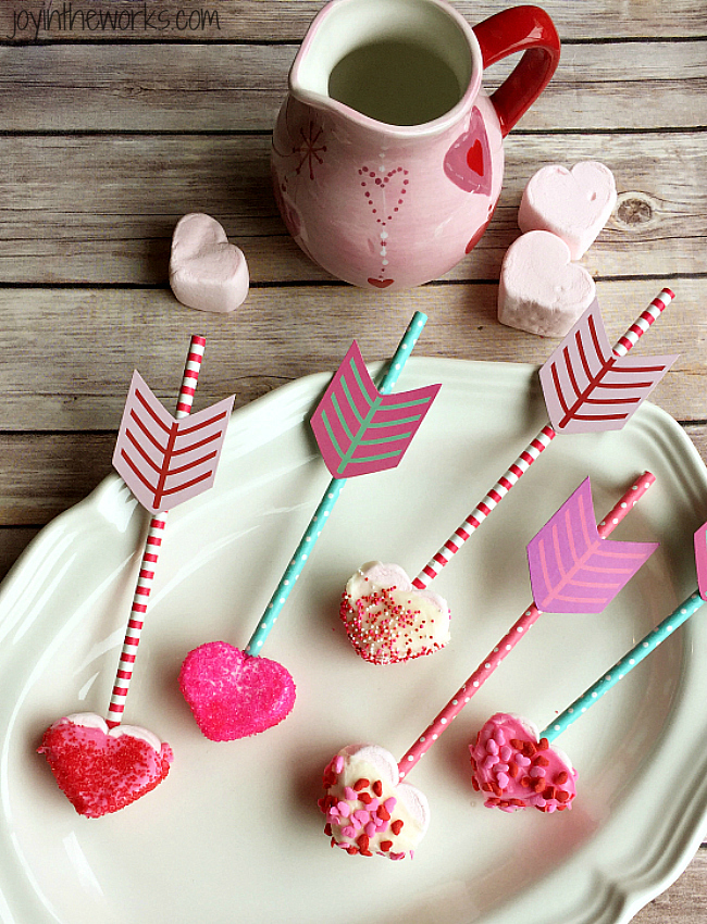 Easy Valentine treat: Cupid's Marshmallow Arrows with dipped and coated heart marshmallows on an arrow straw! No candy dipping necessary however- simply add sprinkles for a festive Valentine sweet! Perfect for a class Valentine party or a Valentine's Day gift!