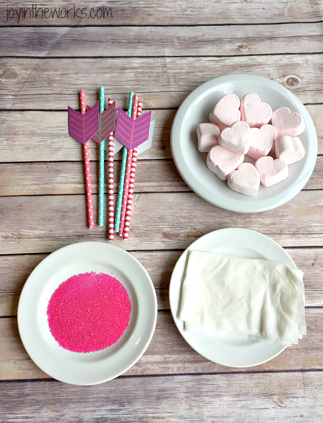 Easy Valentine treat: Cupid's Marshmallow Arrows with dipped and coated heart marshmallows on an arrow straw! No candy dipping necessary however- simply add sprinkles for a festive Valentine sweet! Perfect for a class Valentine party or a Valentine's Day gift!