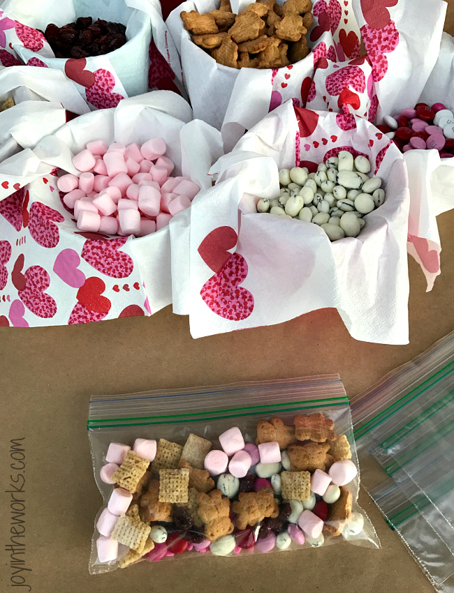 Valentine's Day Snack Mix: Pink Marshmallows, Vanilla Check, Yogurt Covered Raisin, Dried Cranberries,, Teddy Grahams and Valentine Colored M&M's, Use the Printable Follow-Along Instructions for the kids to build their own Valentine's Day snack!