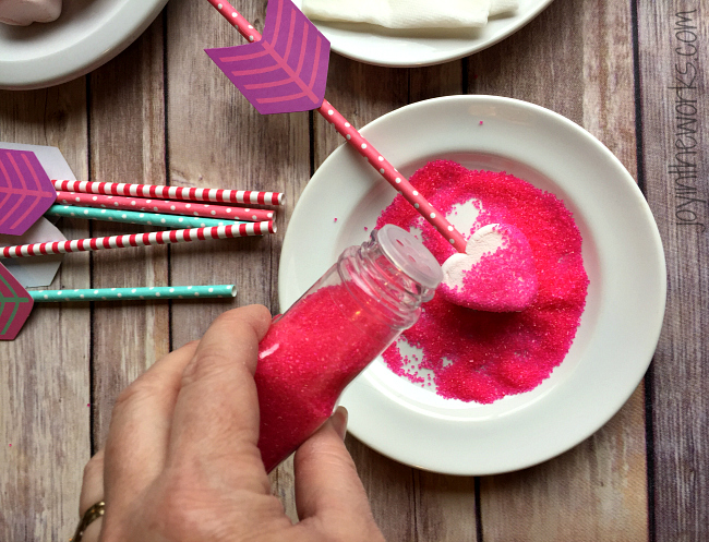 Easy Valentine treat: Cupid's Marshmallow Arrows with dipped and coated heart marshmallows on an arrow straw! No candy dipping necessary however- simply add sprinkles for a festive Valentine sweet! Perfect for a class Valentine party or a Valentine's Day gift!