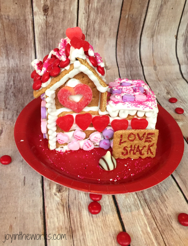 Gingerbread houses aren't just for Christmas! Why not take advantage of all the Valentine's Day candy and make a Valentine Candy House? So easy to make and so fun for the kids! A Valentine Gingerbread House (or Love Shack) would make a great Valentine's Day class party activity too!