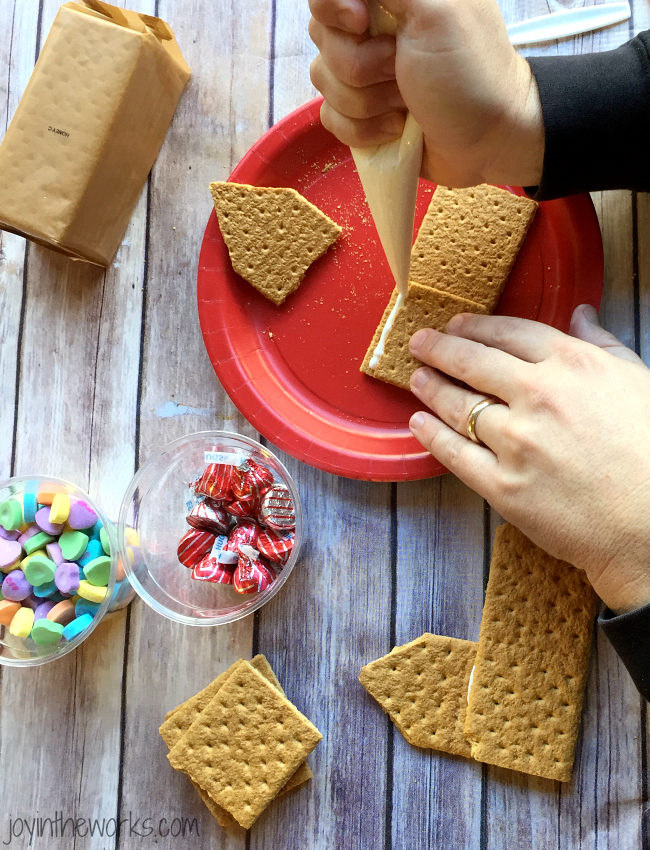 Gingerbread houses aren't just for Christmas! Why not take advantage of all the Valentine's Day candy and make a Valentine Candy House? So easy to make and so fun for the kids! A Valentine Gingerbread House would make a great Valentine's Day class party activity too!