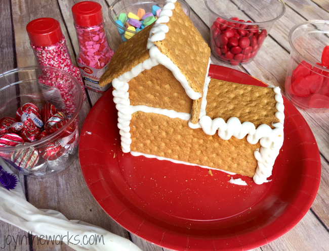 Gingerbread houses aren't just for Christmas! Why not take advantage of all the Valentine's Day candy and make a Valentine Candy House? So easy to make and so fun for the kids! A Valentine Gingerbread House would make a great Valentine's Day class party activity too!