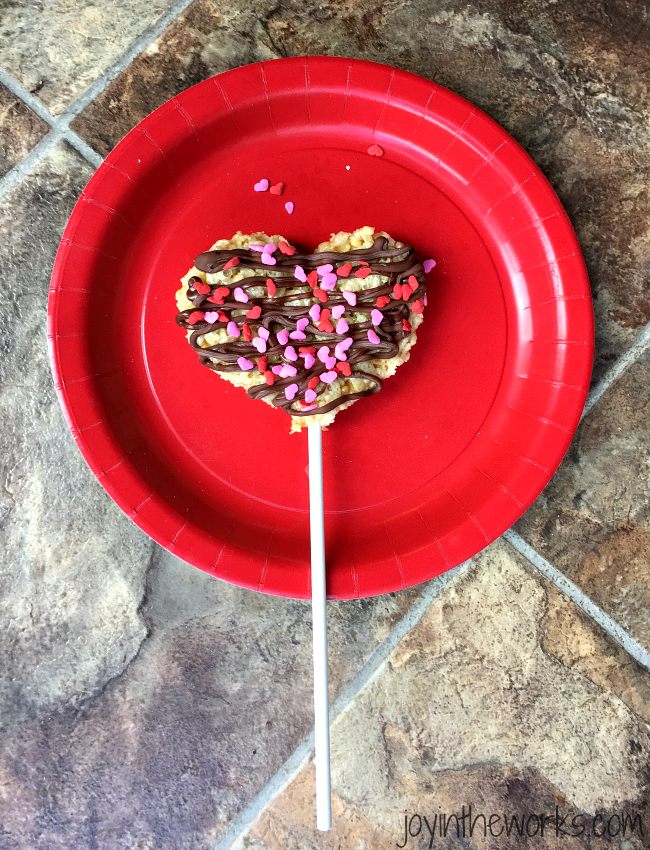 Drizzle white chocolate or chocolate on your heart rice krispie treat pops and then sprinkle with spinkles. Let harden.