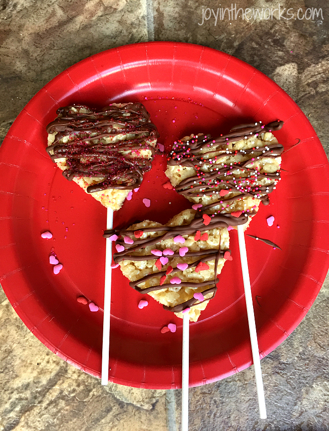 Drizzle white chocolate or chocolate on your heart rice krispie treat pops and then sprinkle with spinkles. Let harden.