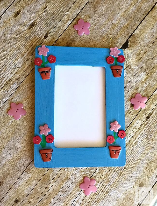 Such an easy Mother's Day gift! To mkae a Mother's Day Flower Button Frame simply paint a frame, add flower buttons (and flower pot buttons if you are lucky enough to find them!) and add stems! So easy that a kid not only can make it, but should make it as a gift for a mom or a grandmother!