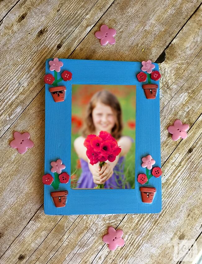 Such an easy Mother's Day gift! To mkae a Mother's Day Flower Button Frame simply paint a frame, add flower buttons (and flower pot buttons if you are lucky enough to find them!) and add stems! So easy that a kid not only can make it, but should make it as a gift for a mom or a grandmother!