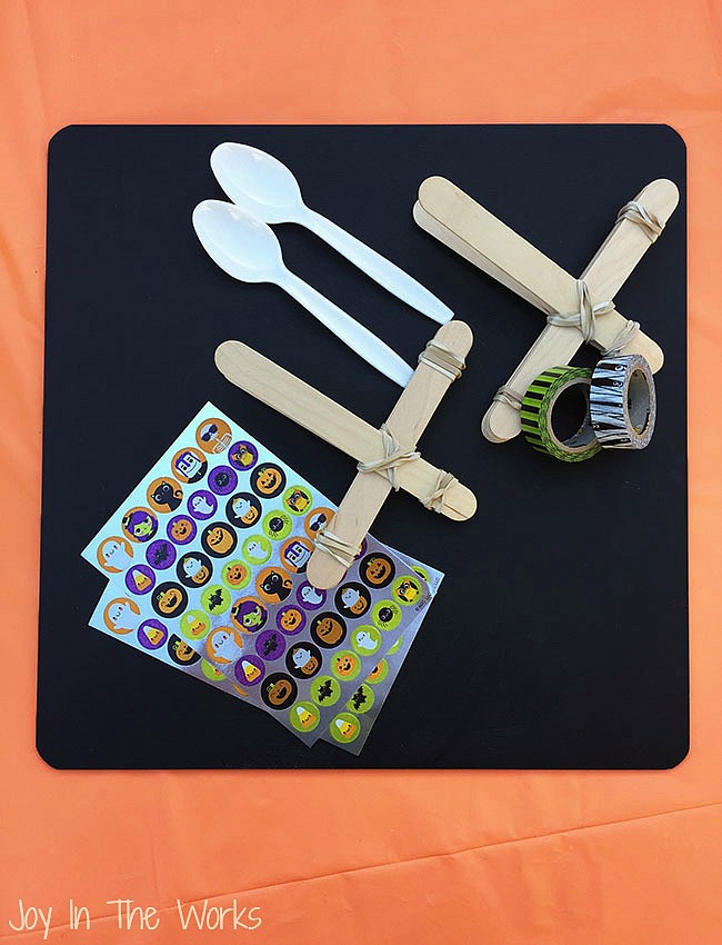The perfect Halloween STEM activity is a Candy Corn Catapult! Even better? Try launching the candy corn, eyeballs and mini-pumpkins into cauldron targets!