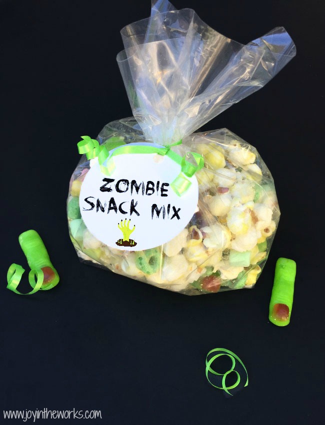 Throwing a Halloween party for kids? Looking for a creative Halloween themed snack? This Zombie Snack Mix for kids is the perfect Halloween party food with its gummy fingers, eyeballs and bones! For an extra special touch, add a green candy coating and green snack foods in green zombie cups for a true Zombie theme! #HalloweenPartyFood #ZombieSnackMix