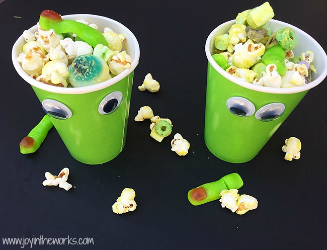 Throwing a Halloween party for kids? Looking for a creative Halloween themed snack? This Zombie Snack Mix for kids is the perfect Halloween party food with its gummy fingers, eyeballs and bones! For an extra special touch, add a green candy coating and green snack foods in green zombie cups for a true Zombie theme! #HalloweenPartyFood #ZombieSnackMix